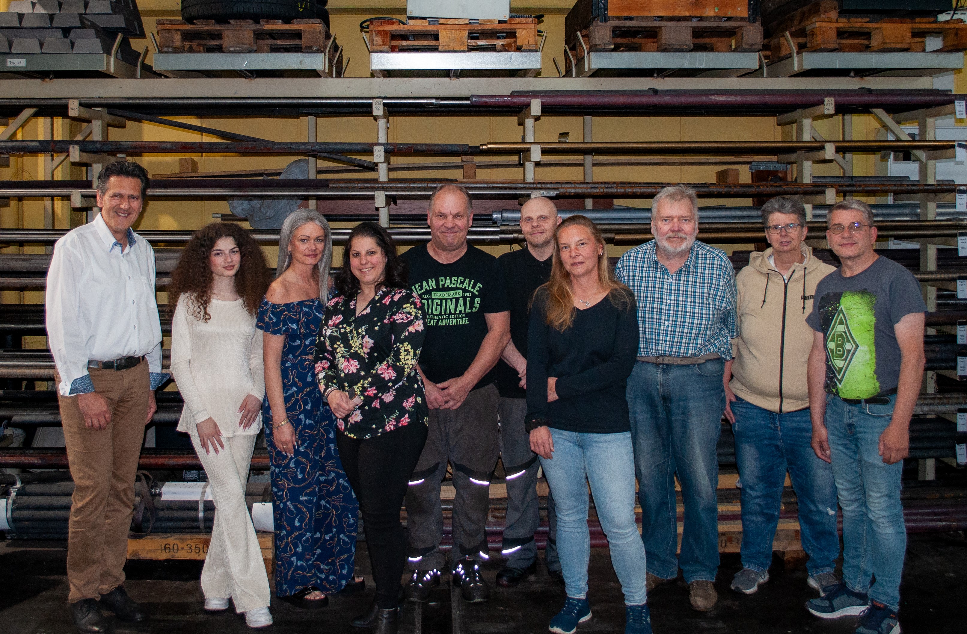 Zu sehen ist das komplette Team der SUS Nell GmbH. Ein Gruppenfoto im Lager.