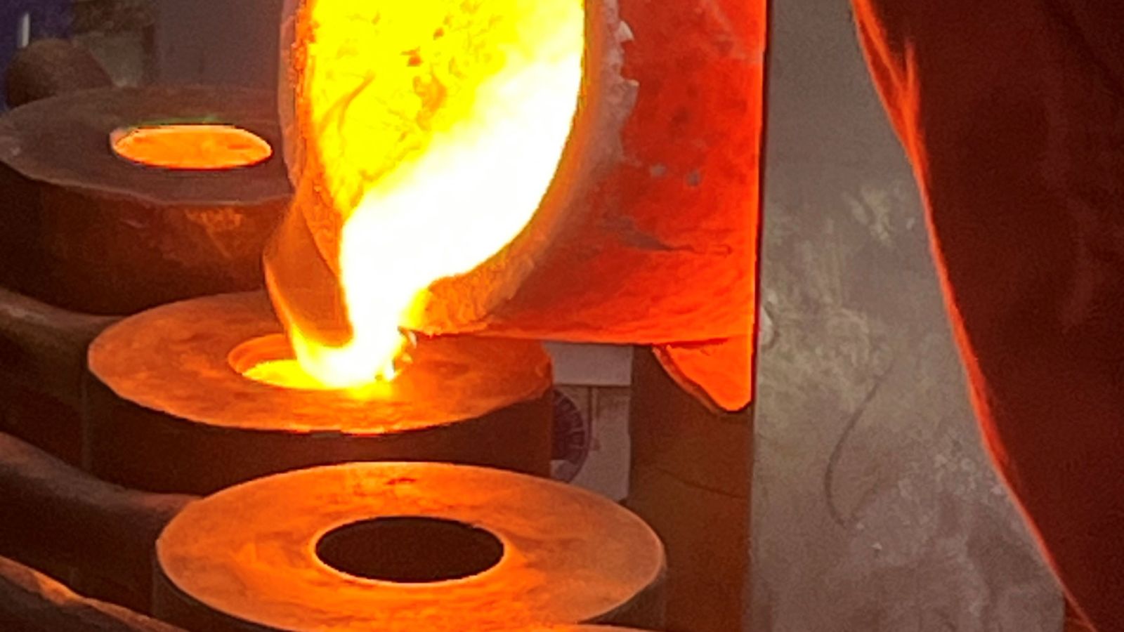 Zu sehen ist wie geschmolzenes Metall in die Form gegossen wird.